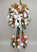 Red and white standing funeral spray with anthuriums, lilies, roses, and greenery
